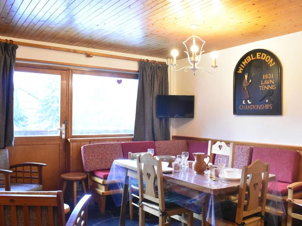une salle à manger avec une table et des chaises en bois dans l'établissement Appartement cozy à Méribel, 6 pers, proche pistes, commerces et navette, cheminée, balcon sud. - FR-1-180-160, à Méribel