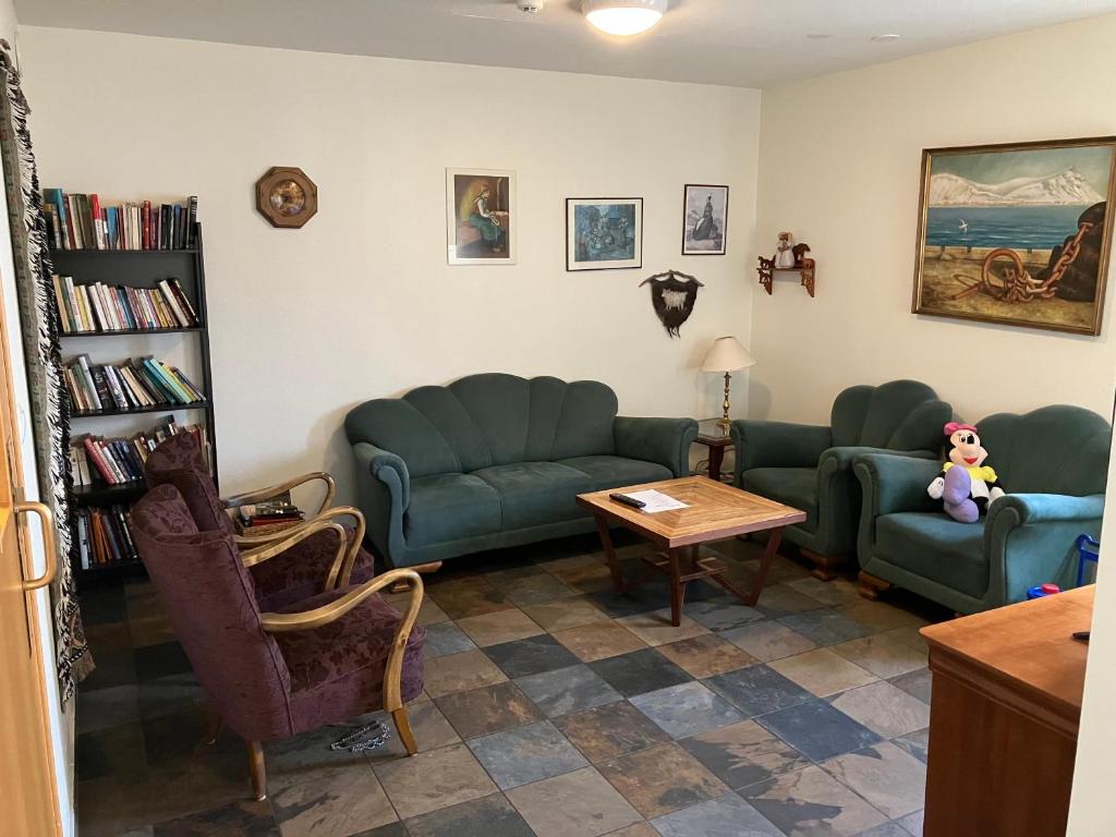 uma sala de estar com sofás verdes e uma mesa em Start Keflavík Airport em Keflavík