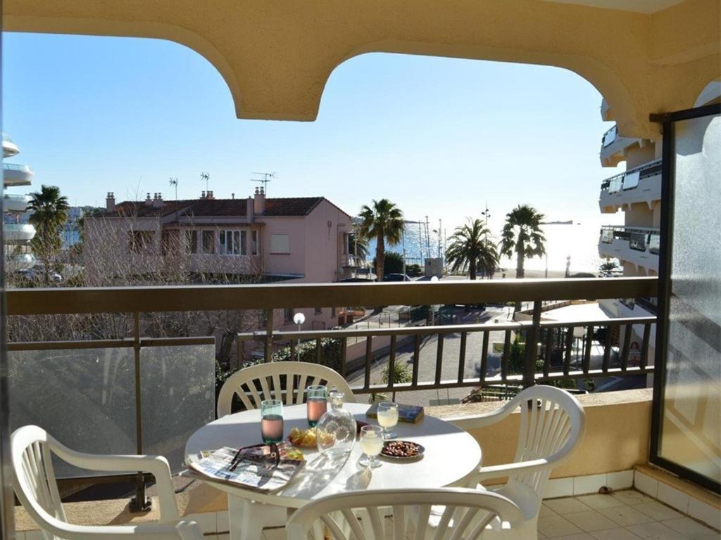 un tavolo e sedie su un balcone con vista sull'oceano di Appartement Fréjus, 1 pièce, 4 personnes - FR-1-226A-57 a Fréjus