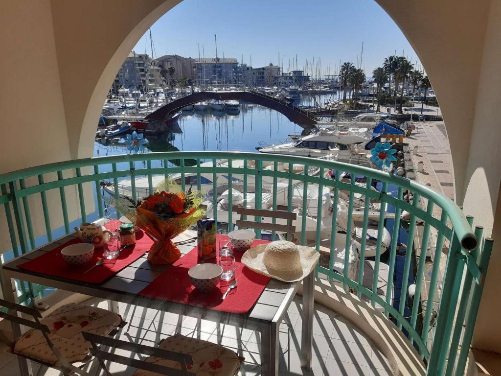 une table sur un balcon avec vue sur un port dans l'établissement Appartement 2 pièces avec terrasse et parking, proche thalassothérapie - FR-1-226A-29, à Fréjus