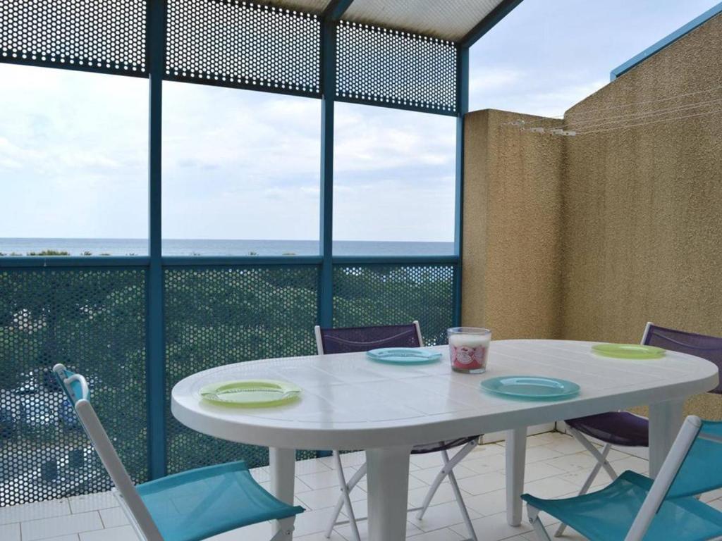 - une table et des chaises blanches avec vue sur l'océan dans l'établissement Location Appart 2 pièces au port d'Argelès-sur-Mer - FR-1-225-56, à Argelès-sur-Mer