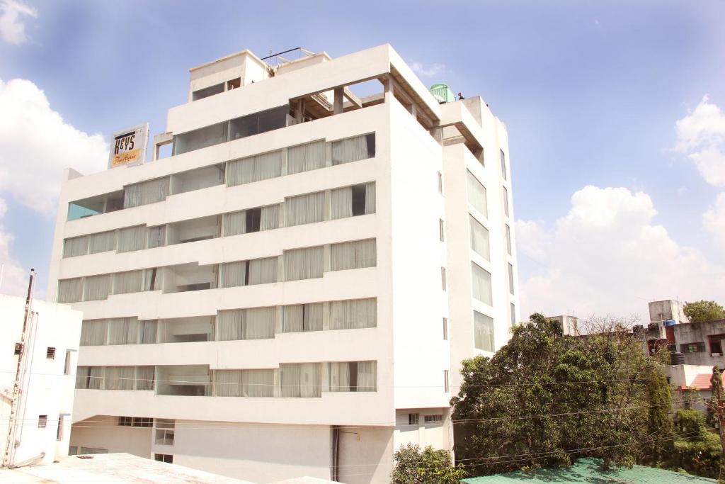 a white building with a pool in front of it at The Aures (formerly known as Keys Select The Aures) in Aurangabad
