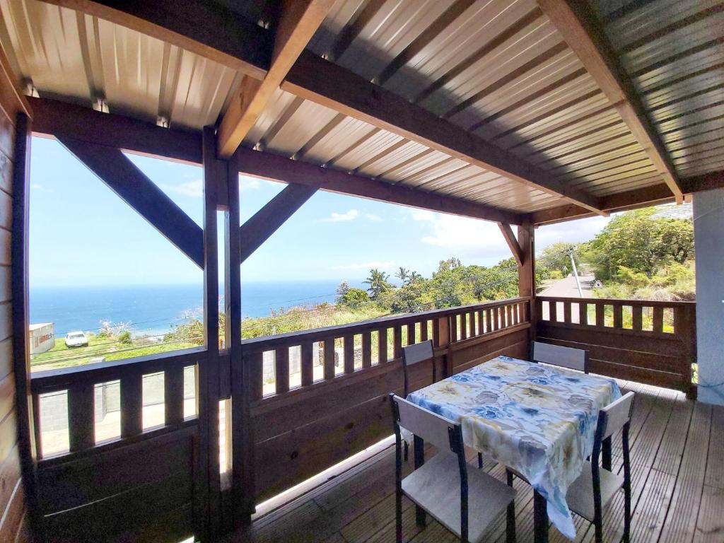 einen Tisch und Stühle auf einer Veranda mit Meerblick in der Unterkunft La Casa Emy in Saint-Leu