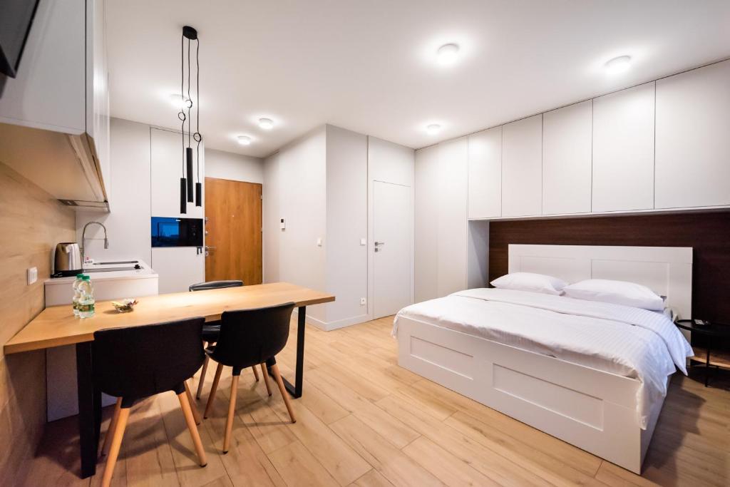 een slaapkamer met een bed, een bureau en een keuken bij 7th Floor Atelier Praga Studio in Warschau