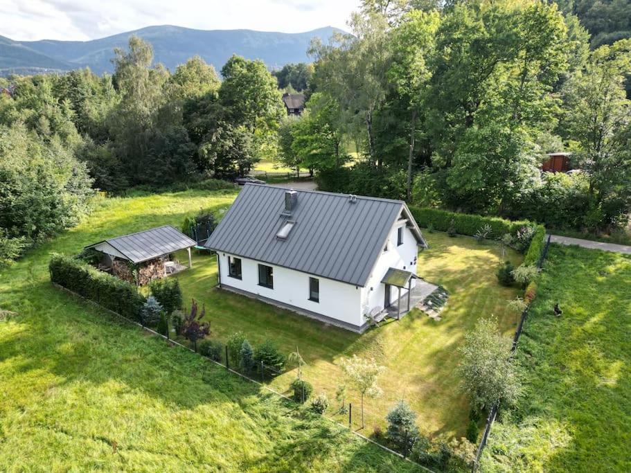an aerial view of a white house in a field at Cicha Ostoja in Miłków