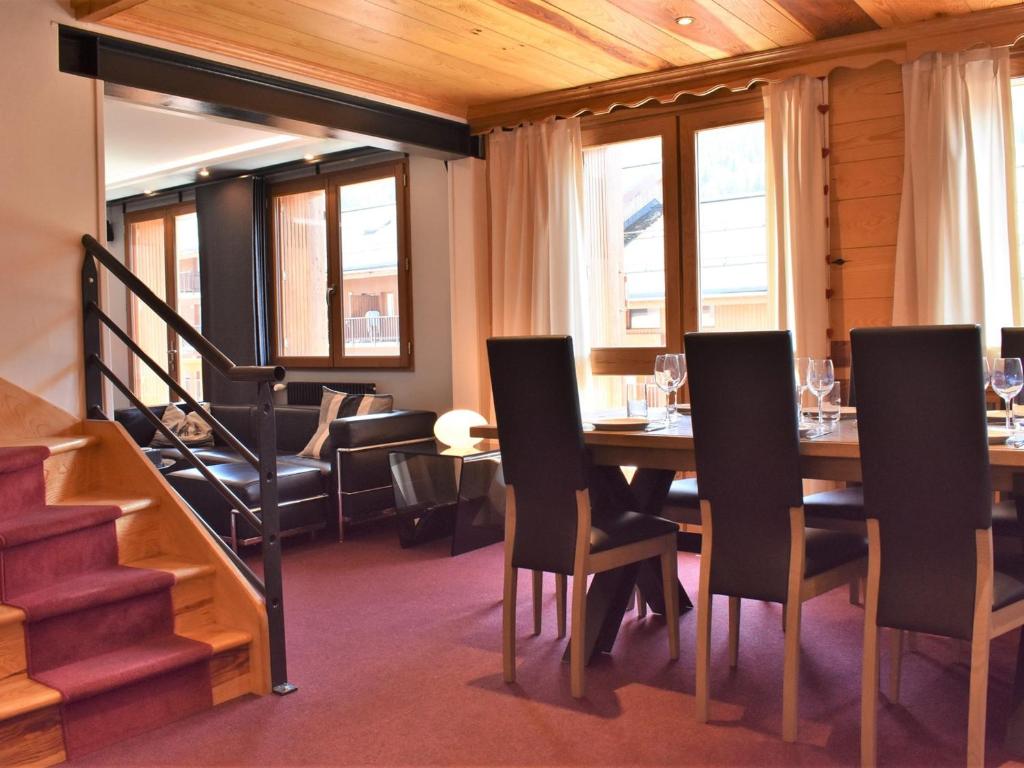 ein Esszimmer mit einem Tisch, Stühlen und einer Treppe in der Unterkunft Appartement Méribel, 6 pièces, 10 personnes - FR-1-180-133 in Méribel