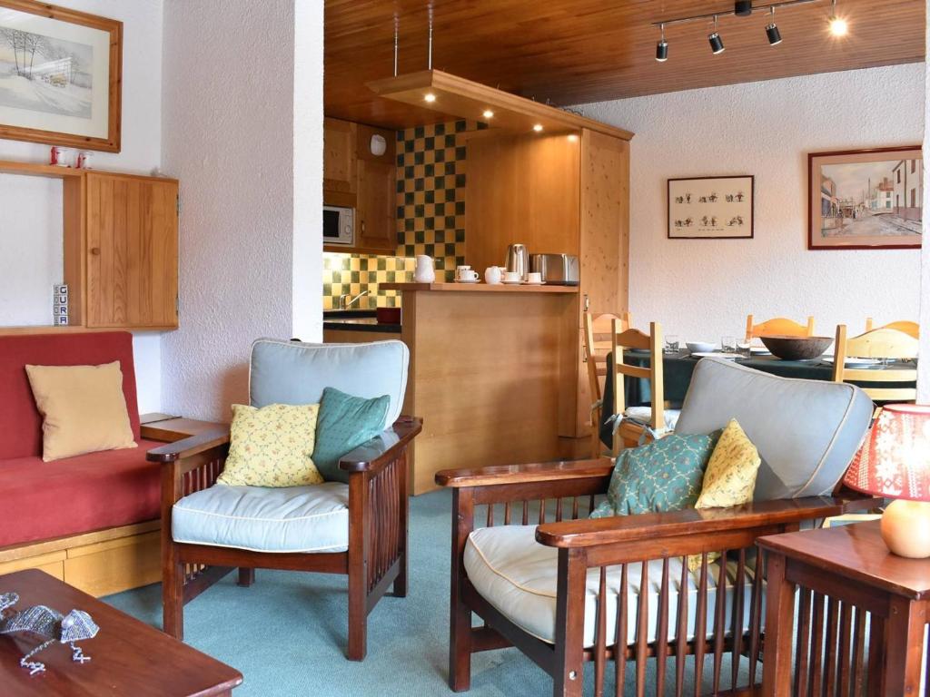 a room with chairs and tables and a kitchen at Appartement 3 pièces avec balcon et WIFI à 150m des pistes, 6 personnes - Méribel - FR-1-180-155 in Méribel