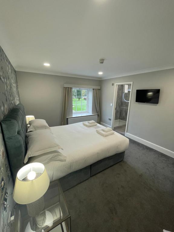 1 dormitorio con cama grande y ventana grande en Hackness Grange, en Broxa