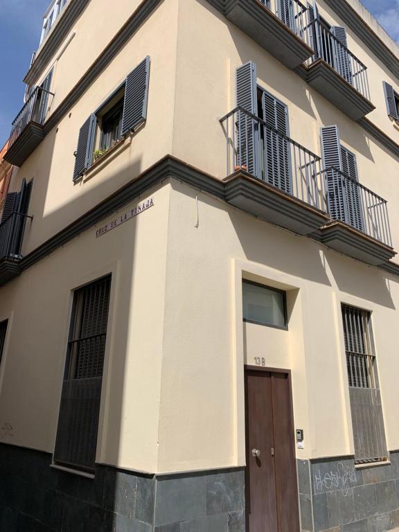 - un bâtiment avec 2 balcons et une porte en bois dans l'établissement Loft Alameda en Sevilla, à Séville