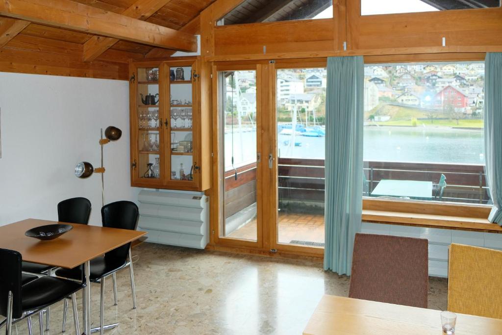 a dining room with a table and chairs and a large window at Seewohnung 1 in Spiez