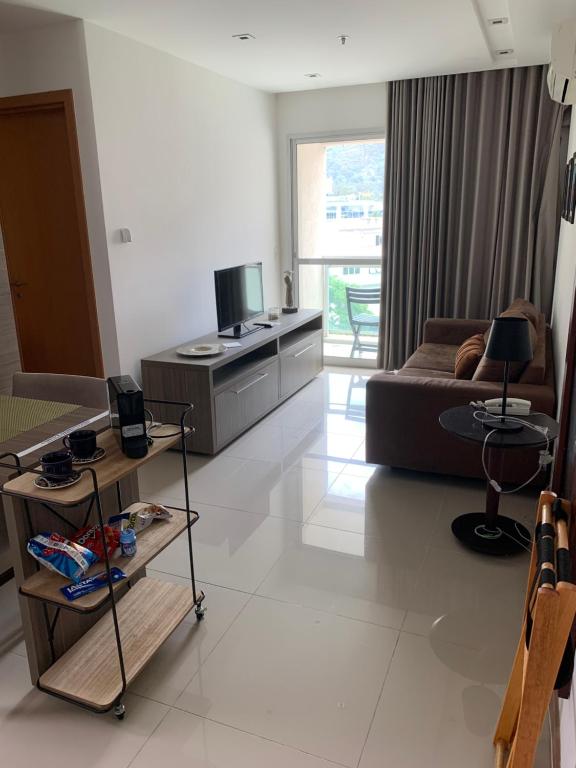 sala de estar con sofá y TV en Flat moderno e sofisticado, en Río de Janeiro