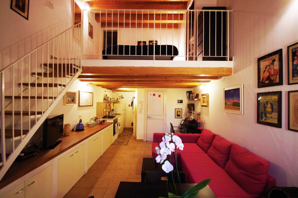 uma sala de estar com um sofá vermelho e uma escada em Piazzetta Santa Barbara em Bari