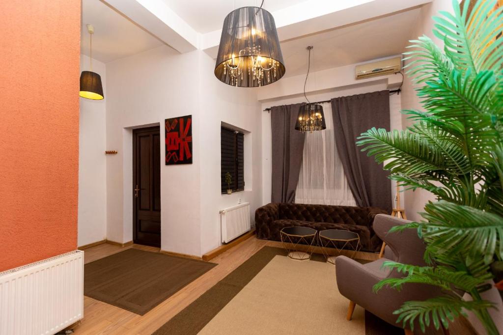 un salon avec un canapé et une plante dans l'établissement Conta Apartments, à Craiova