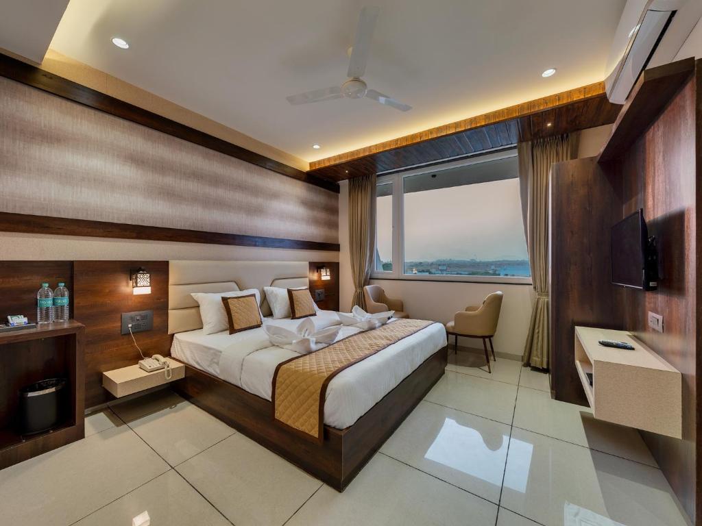 a hotel room with a bed and a large window at Golden Leaf Resort in Dhule