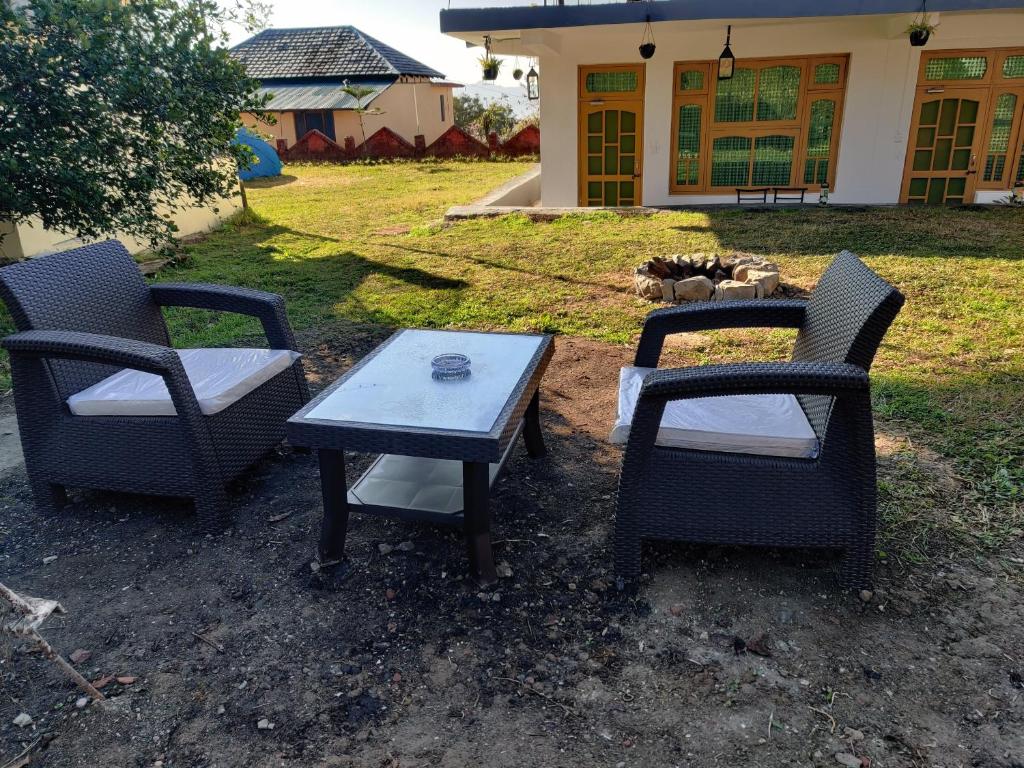 3 sillas y una mesa en un patio en The Hidden Tribe en Bīr
