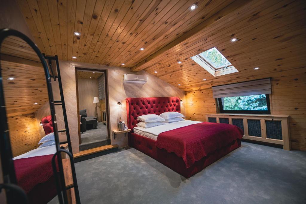 a bedroom with a red bed in a wooden room at Casa Seciu in Ploieşti