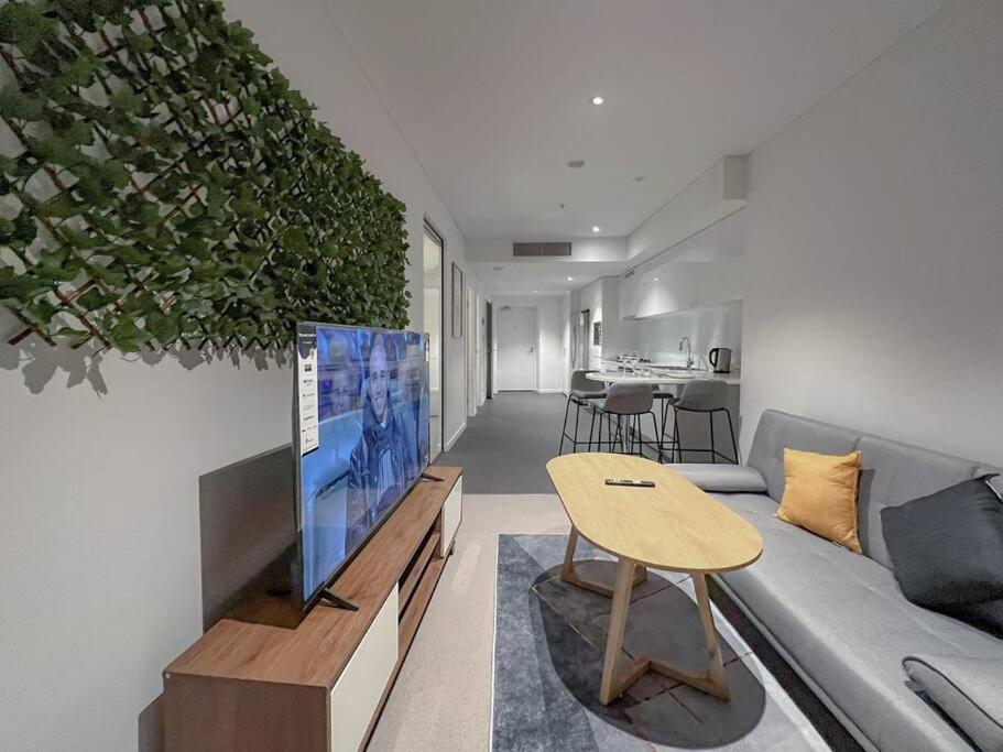 een woonkamer met een bank en een tafel bij Amazing 2 Bedroom in CBD! in Brisbane