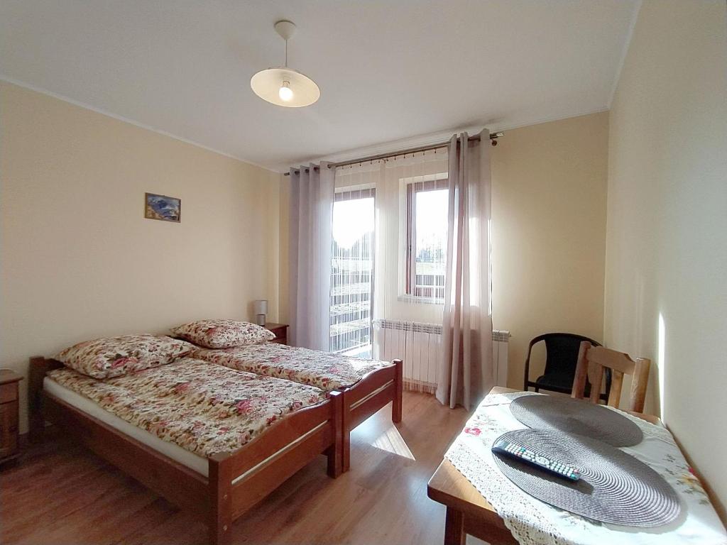 una camera con letto, scrivania e finestra di Pokoje Gościnne Waluś a Murzasichle