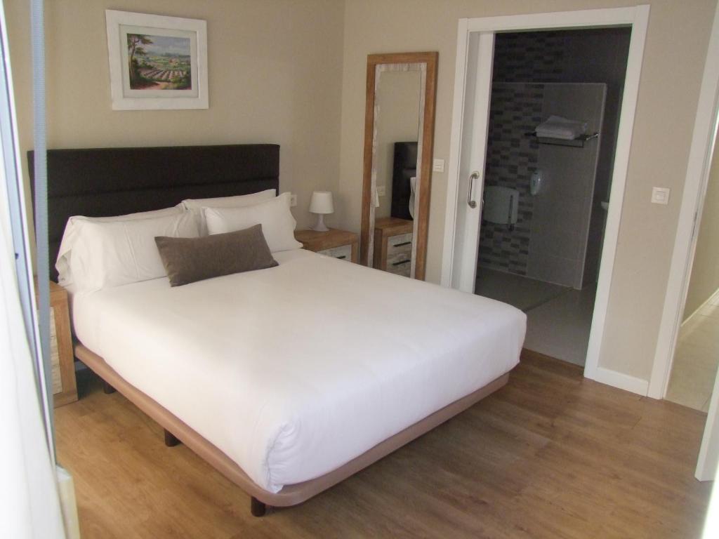 a large bed in a room with a white bed sidx sidx at Real Ferrol in Ferrol