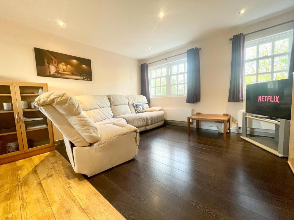 uma sala de estar com um sofá branco e uma televisão em Richmond House (9A) by Staytor Accommodation em Exeter