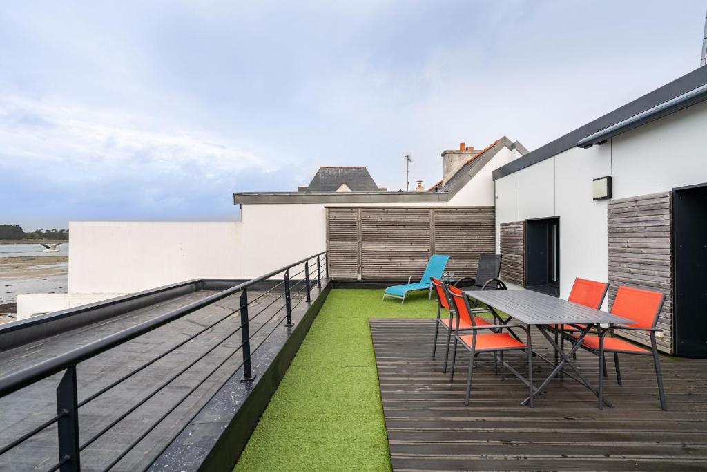 a patio with a table and chairs on a balcony at Appartement vue mer a lIle Tudy in Île-Tudy