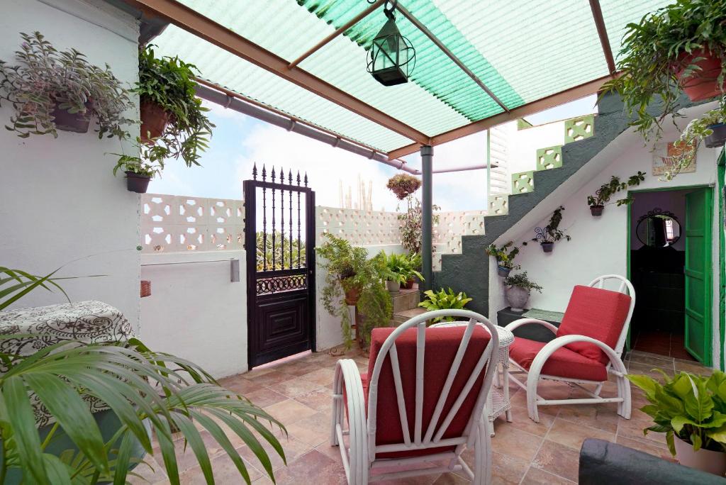 a patio with red and white chairs and a black door at Casa Haba in Sauzal