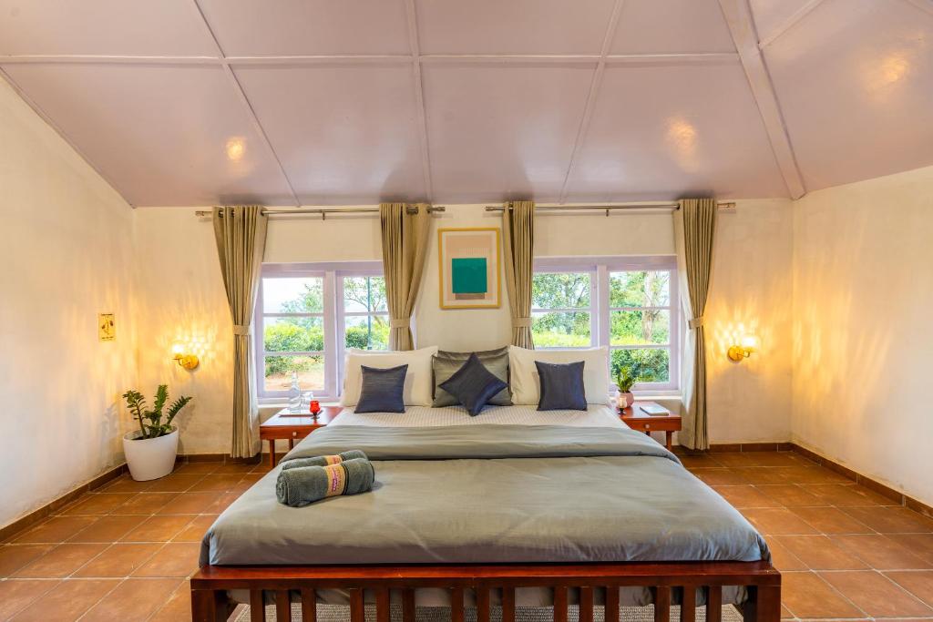 1 dormitorio con 1 cama grande y 2 ventanas en Zostel Plus Wayanad, en Kalpetta
