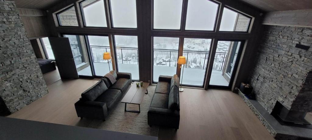 a living room with a couch and a large window at Gausta Residence in Gaustablikk
