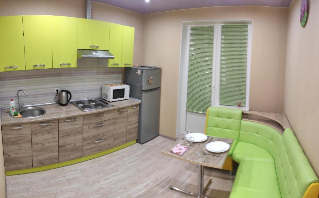 a kitchen with neon green cabinets and a green couch at Apartment near metro Pozniaky in Kyiv