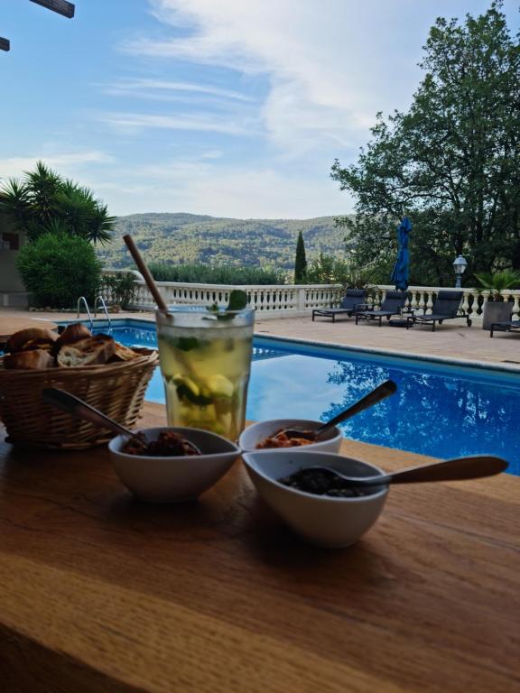 a table with two bowls of food and a drink at Villa Manoe in Draguignan