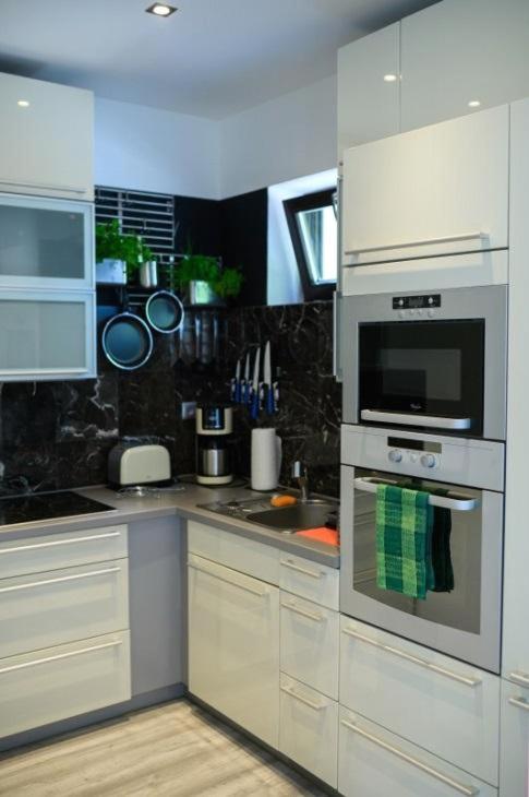 a kitchen with white cabinets and a stainless steel oven at Apartman Kateřinky Liberec in Liberec