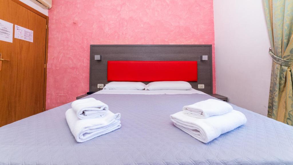 a bedroom with a bed with two towels on it at Hotel Center 1 in Rome