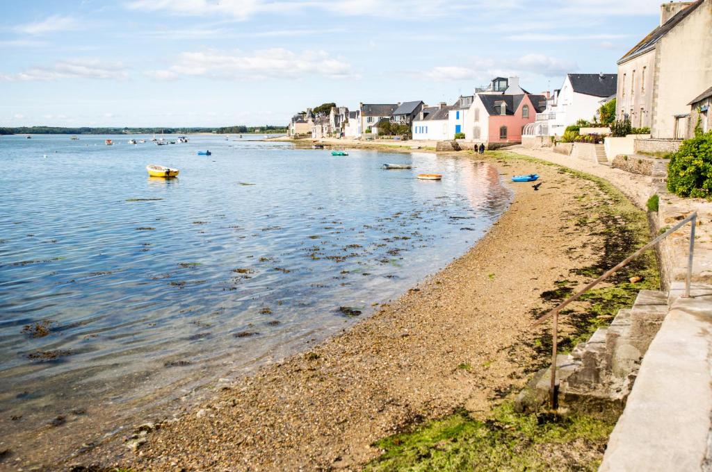 a beach with houses and boats in the water at Appartement vue mer a lIle Tudy in Île-Tudy