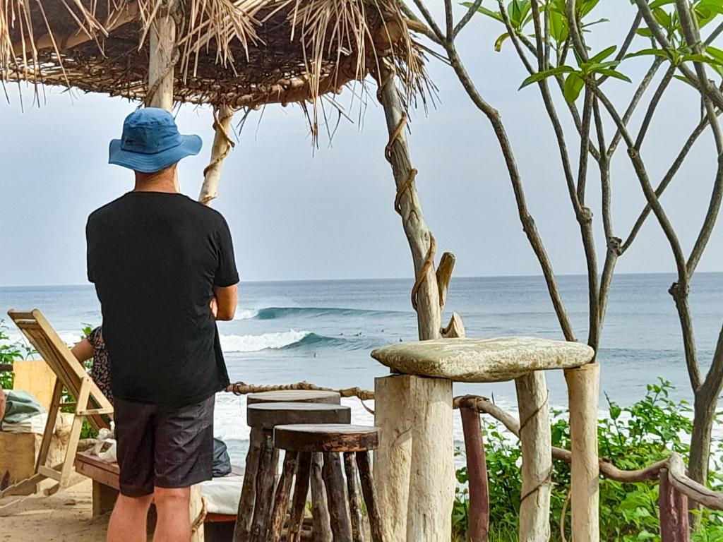 a man standing on the beach looking at the ocean at Popoyo Surfcamp in Popoyo