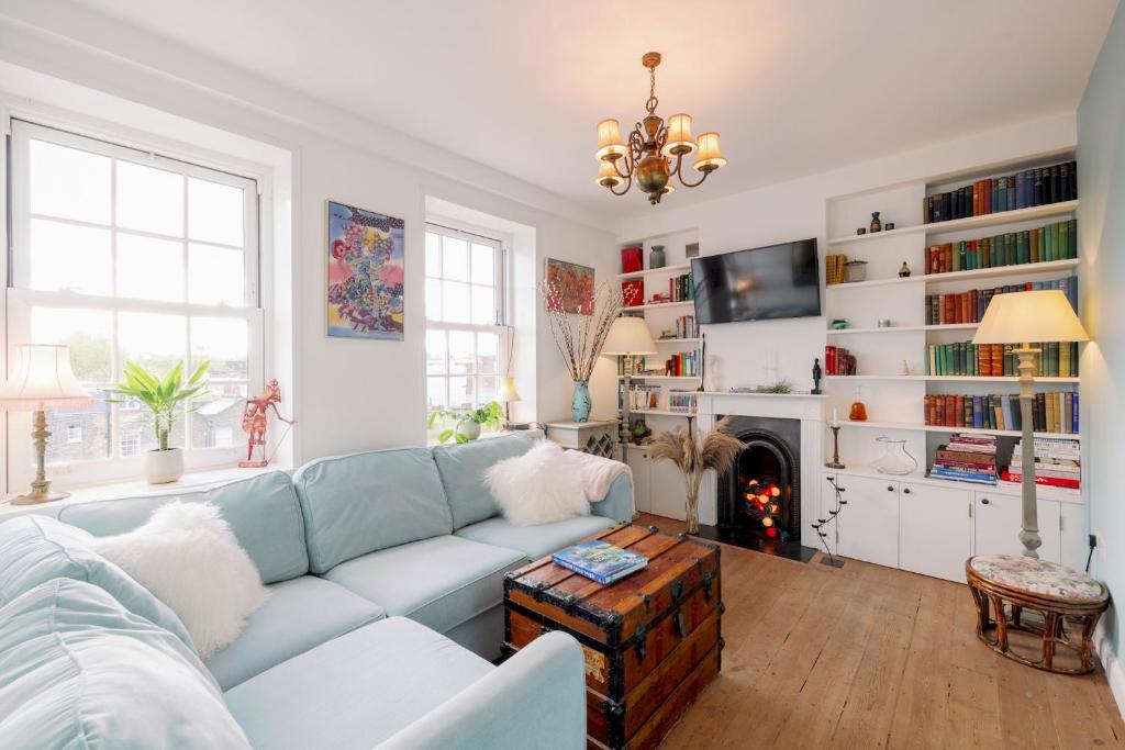 a living room with a blue couch and a fireplace at Pass the Keys Stylish Apartment in the heart of Clerkenwell in London