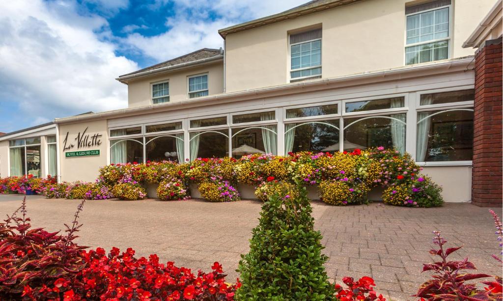 Ein Gebäude mit einem Blumenstrauß davor. in der Unterkunft La Villette Hotel in St Martin Guernsey