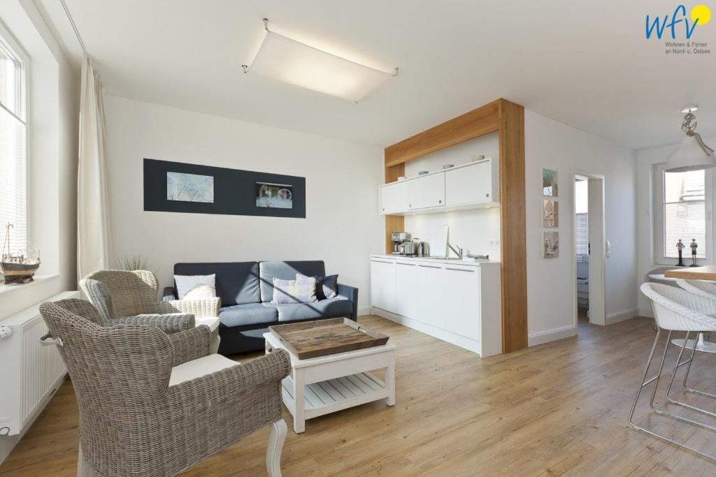 a living room with a couch and a table at Haus Inselrose Ferienwohnung Wildrose in Juist