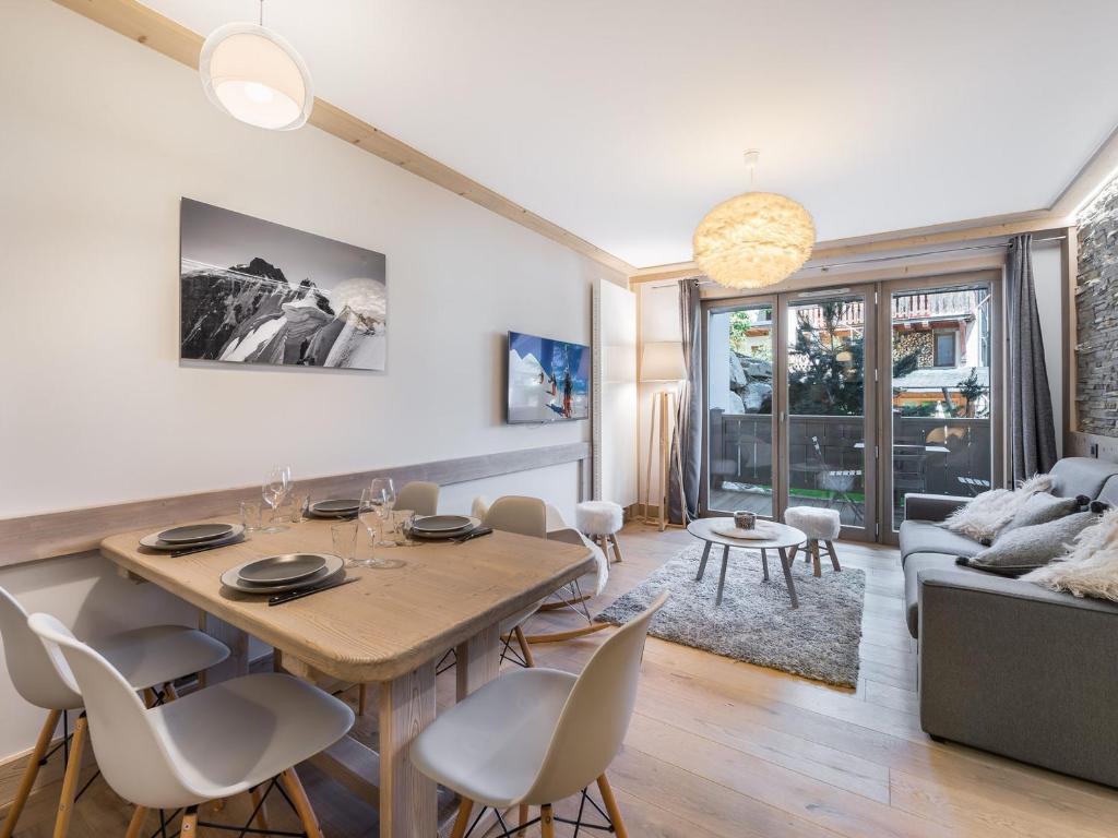 un salon avec une table, des chaises et un canapé dans l'établissement Appartement moderne au cœur de Courchevel Village, proche commerces et pistes, avec espace fitness. - FR-1-562-36, à Courchevel