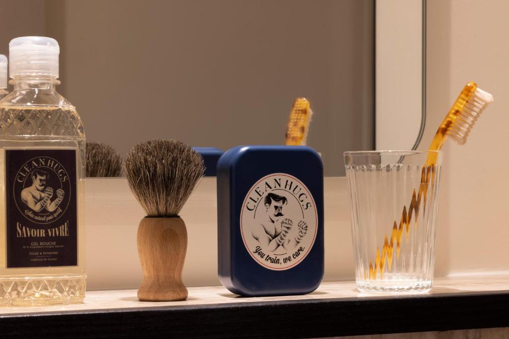 a bathroom counter with a bottle of soap and a toothbrush at Hôtel Toujours &amp; Spa in Paris