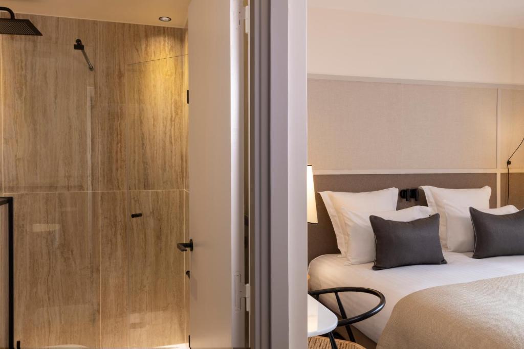 a hotel room with a bed and a shower at Hôtel Toujours &amp; Spa in Paris