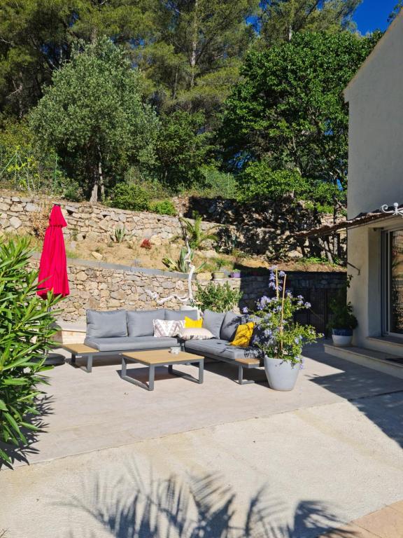 a patio with two couches and a table and some plants at Villa Manoe in Draguignan
