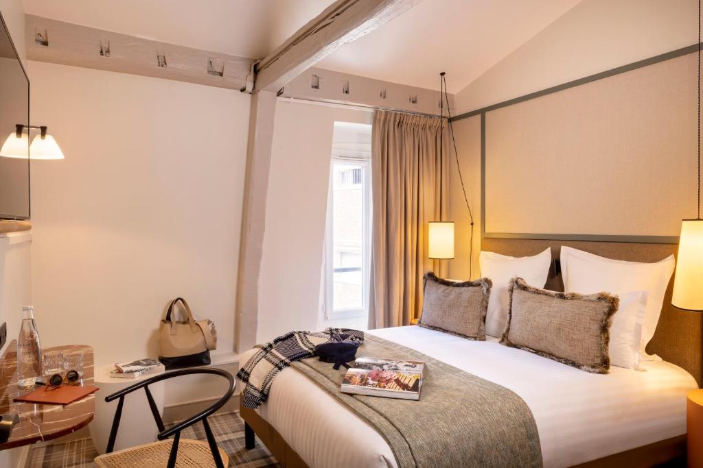 a hotel room with a bed and a table and chairs at Hôtel Toujours &amp; Spa in Paris