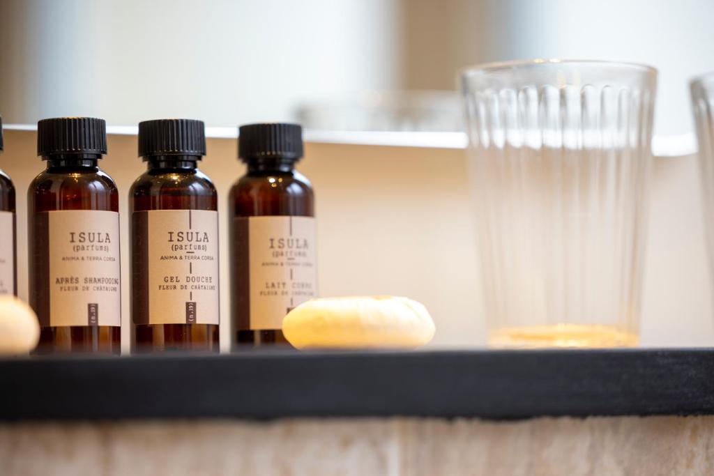 four bottles of essential oils sitting on a shelf at Hôtel Toujours &amp; Spa in Paris