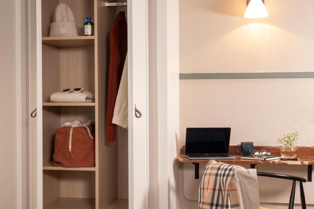 a closet with a desk with a laptop on it at Hôtel Toujours &amp; Spa in Paris