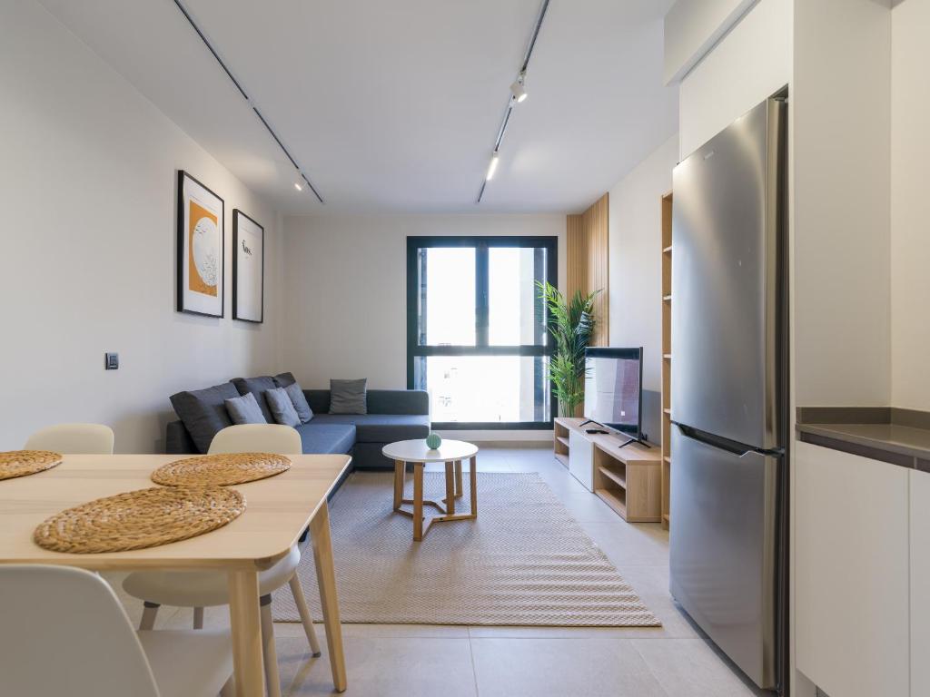 een keuken en een woonkamer met een roestvrijstalen koelkast bij VV Arenas de Guanarteme "by henrypole home" in Las Palmas de Gran Canaria