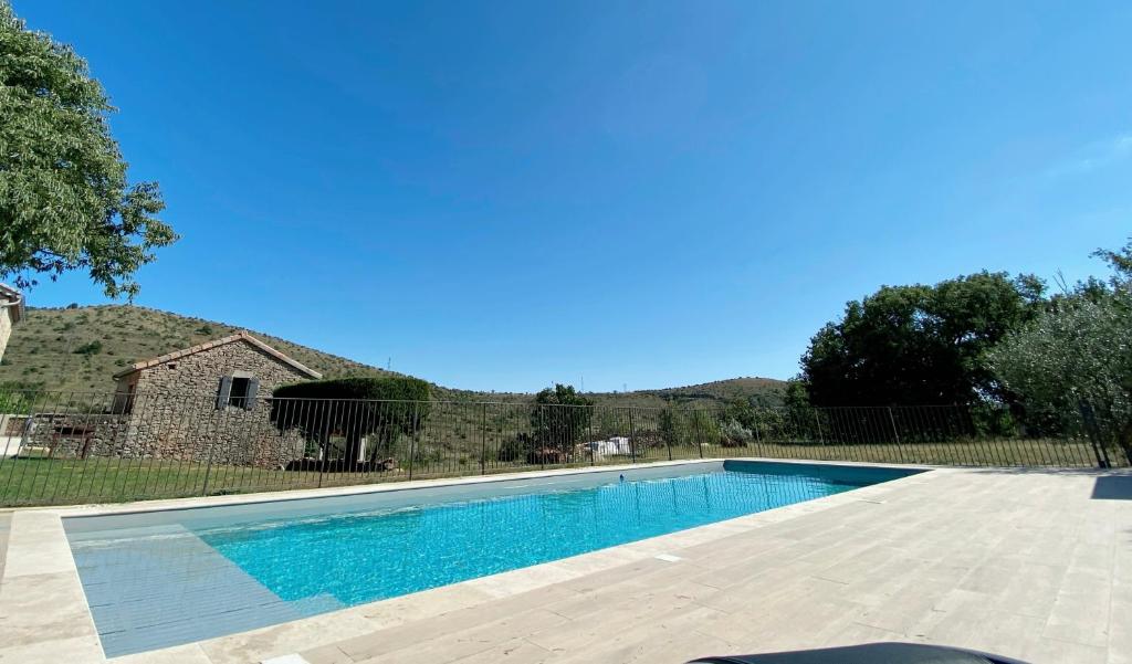 - une piscine en face d'une maison dans l'établissement Mas de Veyras - Gîtes 5 étoiles en Ardèche, à Lachapelle-sous-Aubenas