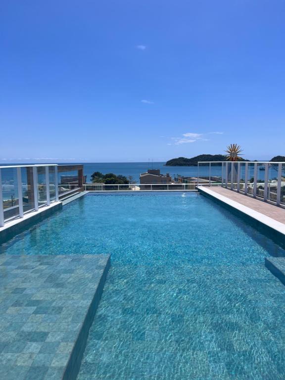 a swimming pool on the roof of a building at Vila do Centro Apart Hotel in Bombinhas