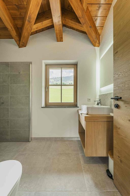 a bathroom with a tub and a sink and a window at Dachstein West Apartment T4 in Russbach am Pass Gschütt