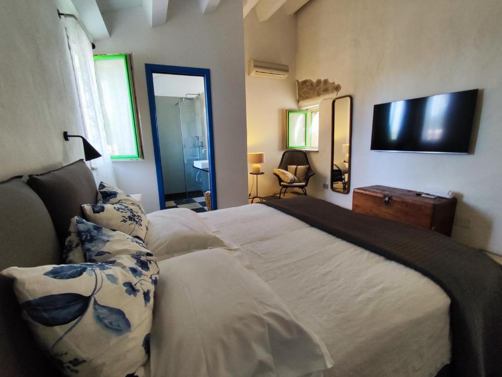 ein Schlafzimmer mit einem Bett und einem TV an der Wand in der Unterkunft Casa Don Michele in Letojanni