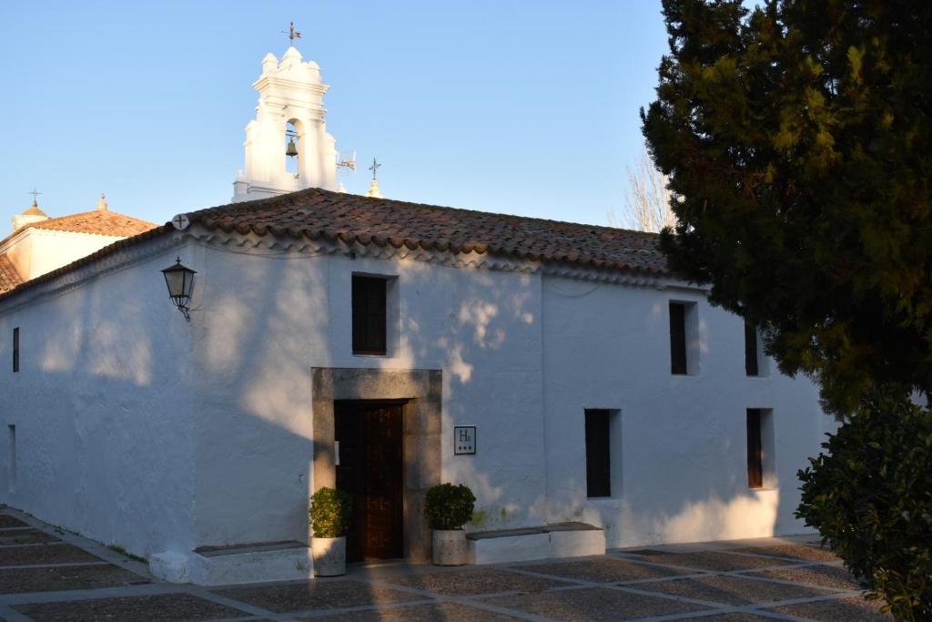 Biały budynek z wieżą na górze w obiekcie Hotel Rural El Refugio de Los Templarios w mieście Cabeza del Buey